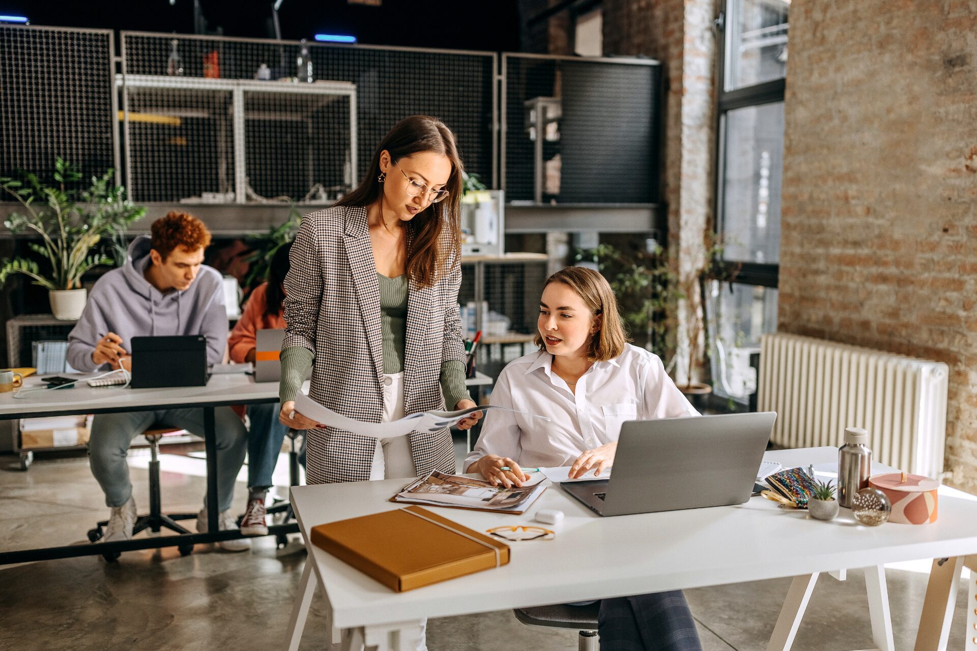 Deux collègues discutant d'un projet au bureau, illustrant le bien-être au travail et la collaboration.