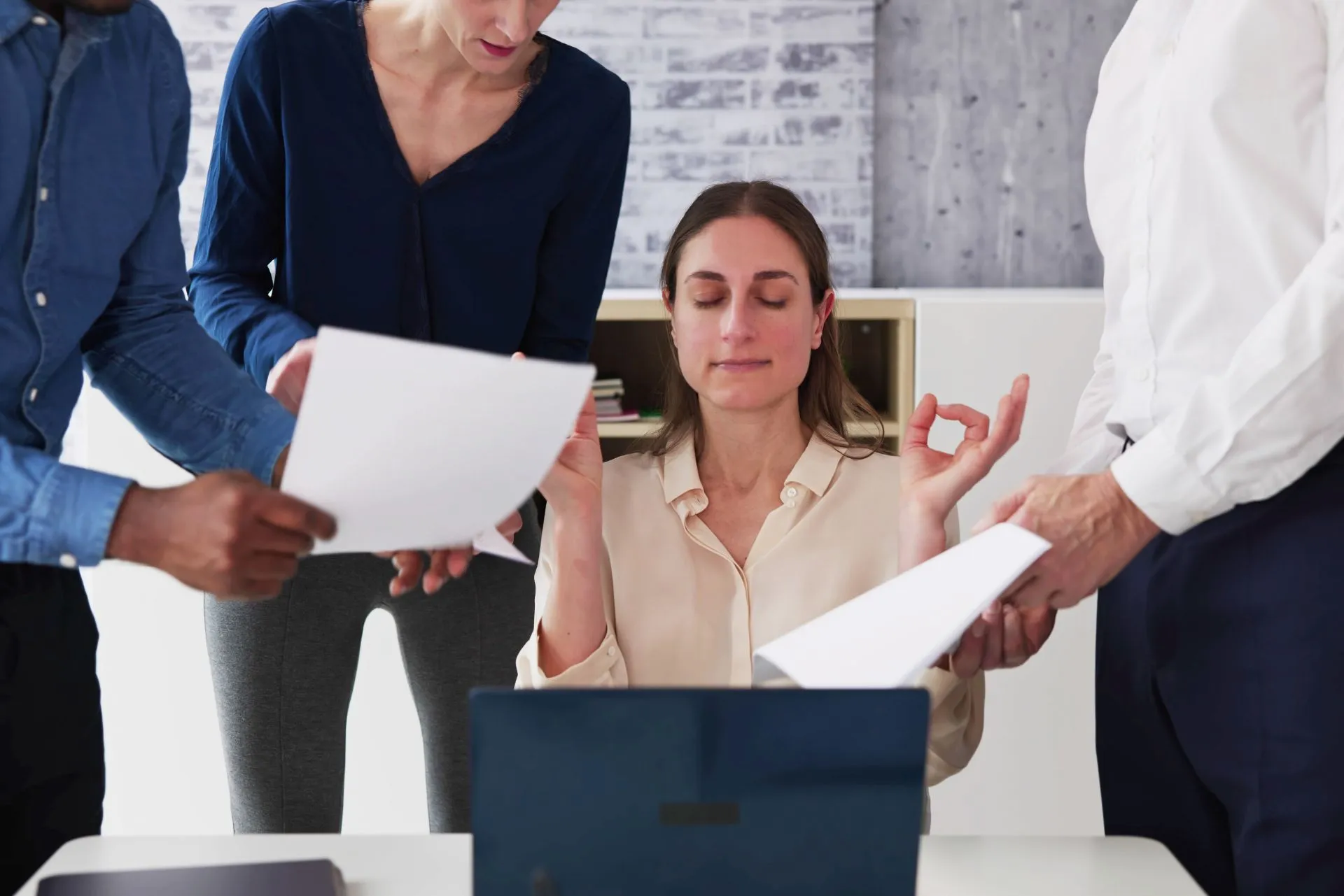 Femme pratiquant une technique de relaxation entourée de collègues, illustrant comment gérer le stress de la rentrée.