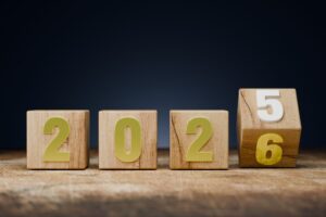 Bilan de fin d’année : cubes en bois représentant les chiffres 2025 et 2026, symbole de transition, d’analyse et de projection vers l’avenir.