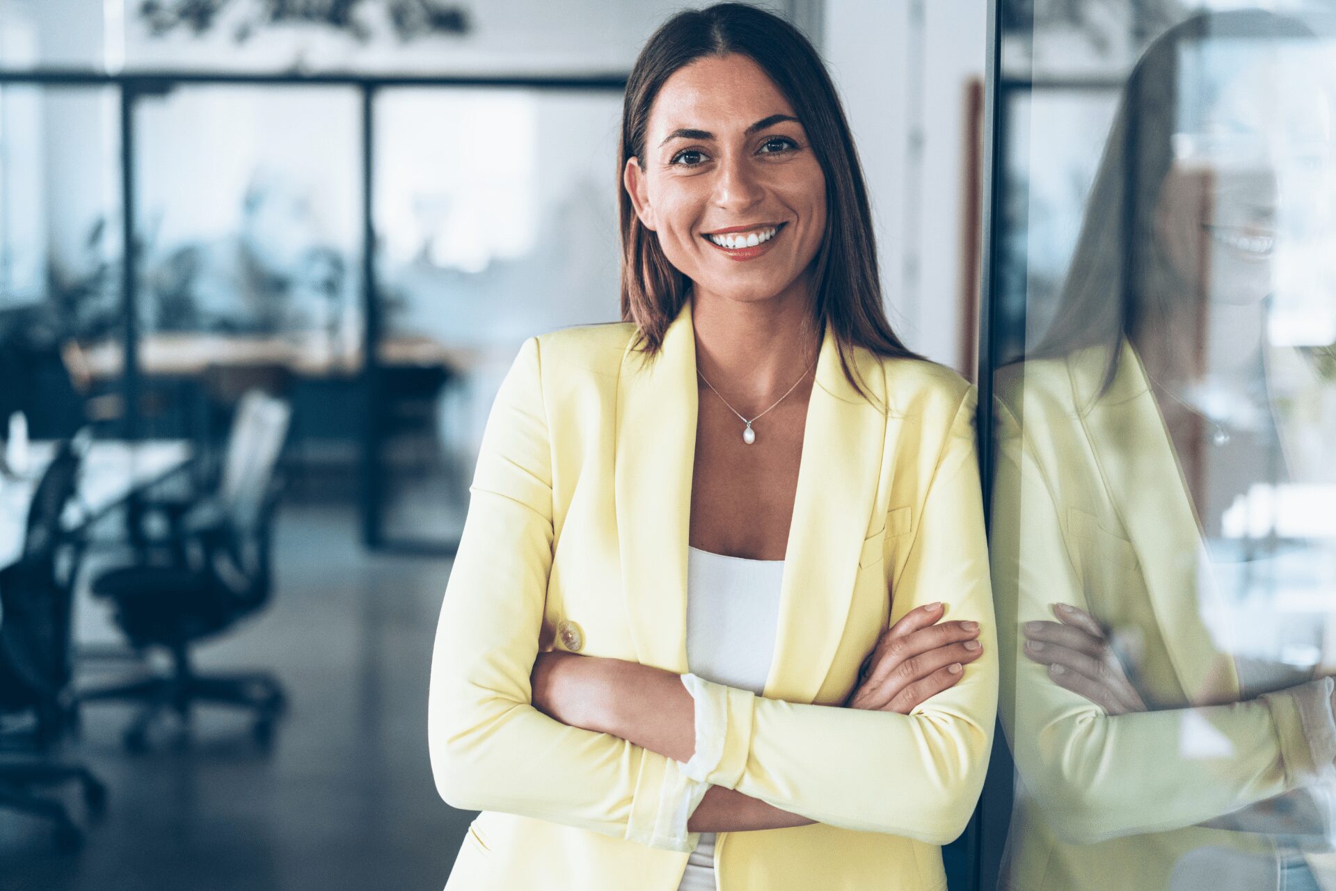 Se sentir légitime : femme souriante et confiante en environnement professionnel, symbole d’affirmation de soi et de reconnaissance.