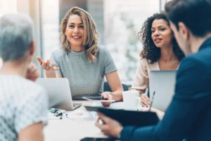 Management bienveillant : une manager échange avec son équipe dans un cadre professionnel collaboratif.